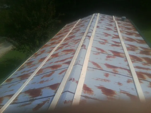 Rusted metal roof panels with new wood purlins before replacement — Storm Damage Roof Repair in Broadview by Roofing Brothers