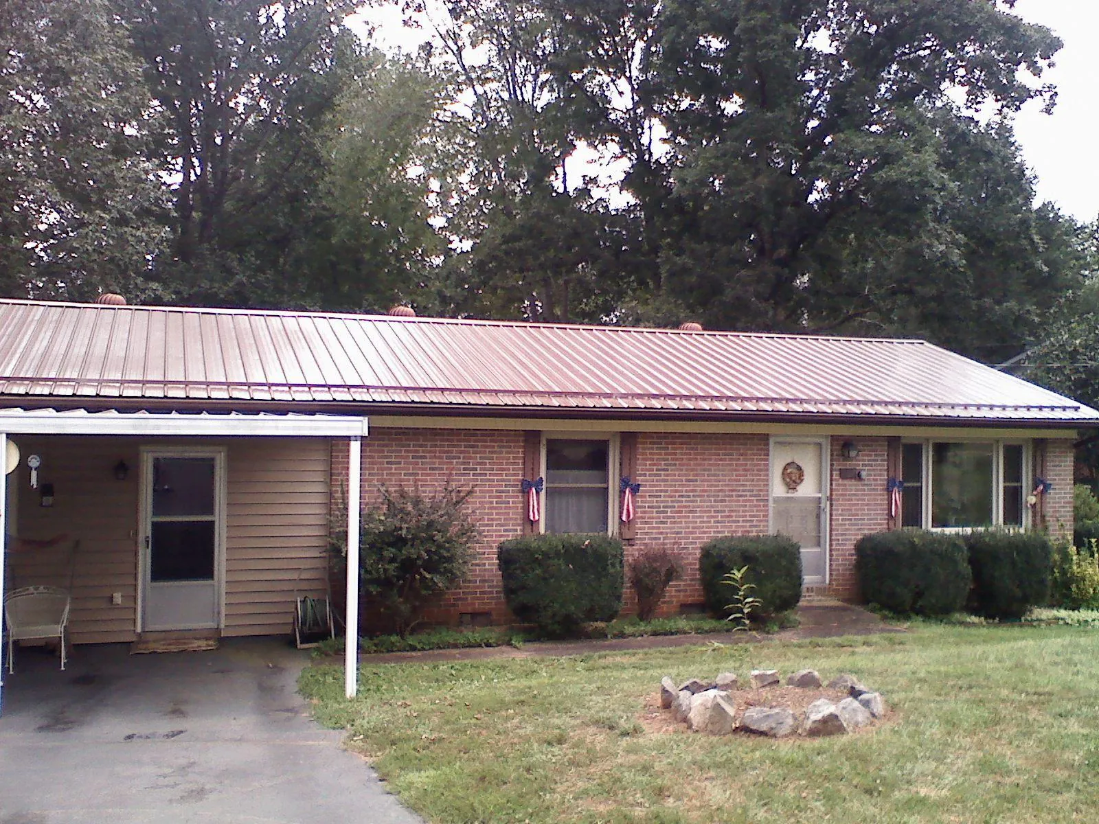 Bronze metal roof and carport on a brick ranch home — Roof Repair work by our crew in Broadview