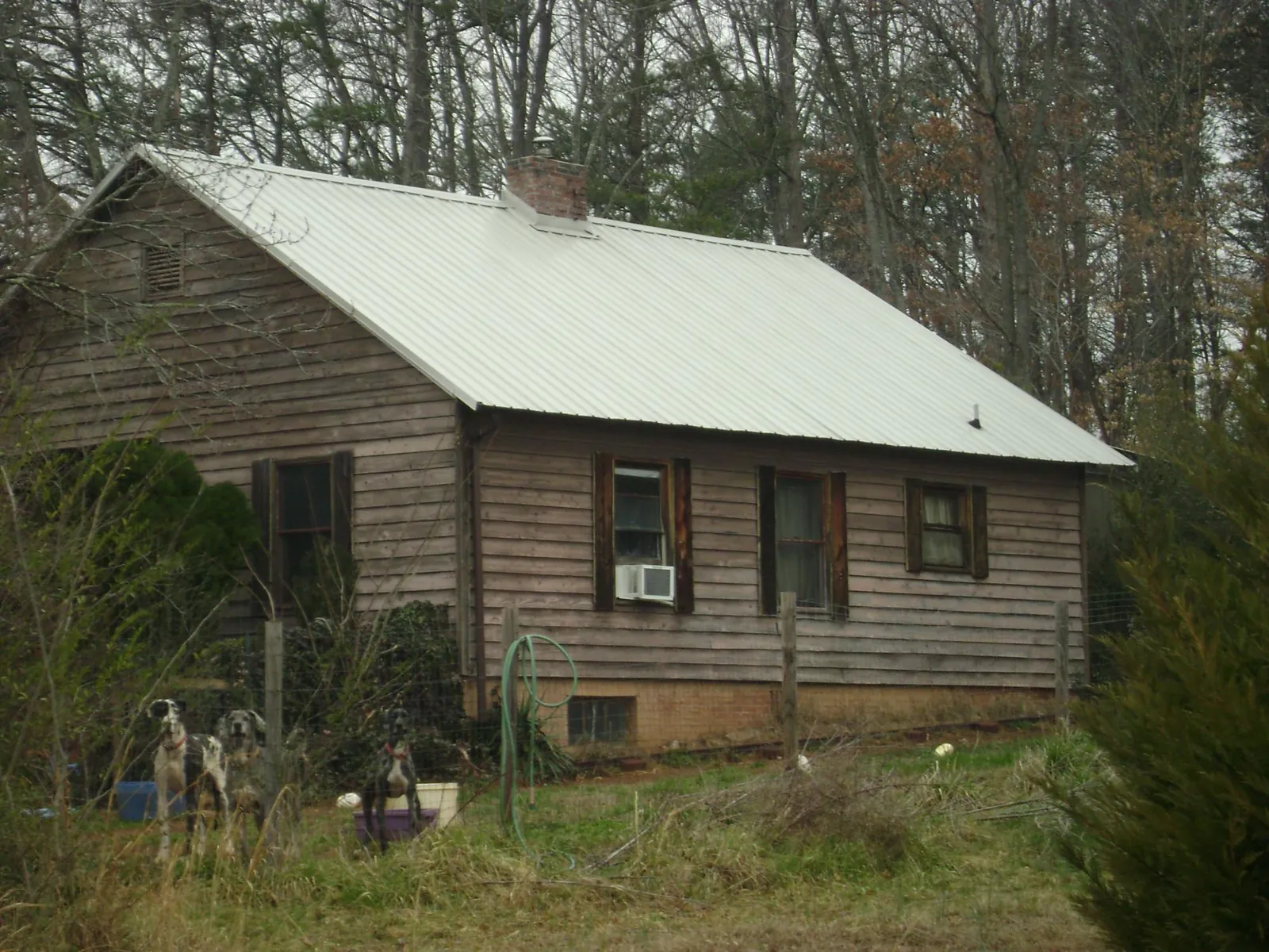 White metal roof on an old wood sided farmhouse, from a Metal Roof Installation job in Broadview